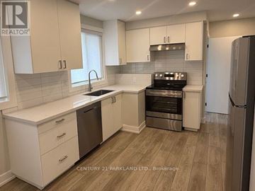 Toronto (Humbermede) apartment for rent - A kitchen with white cabinets and a wooden floor.