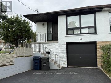 Toronto (Humbermede) apartment for rent - A white house with a black garage door is for sale.