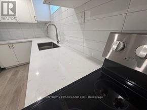 Toronto (Humbermede) apartment for rent - A kitchen with white countertops and a black stove top.