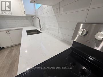 Toronto (Humbermede) apartment for rent - A kitchen with white countertops and a black stove top.