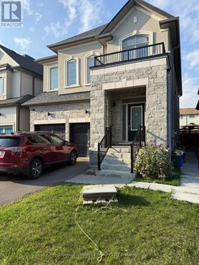 Oshawa (Eastdale) apartment for rent - A red car is parked in front of a two-story house with a stone facade.