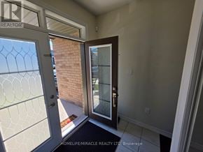 Brantford apartment for rent - A glass door with a handle is open to a brick wall.