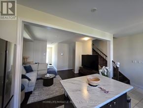 Brantford apartment for rent - A spacious living room with a kitchen area in the background.