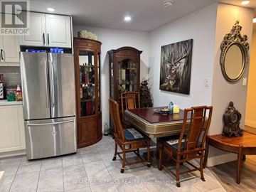 Toronto (Steeles) condo for rent - A kitchen with a table and chairs in the middle of the room.