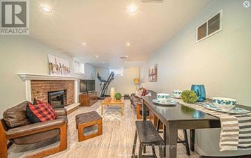 Oshawa (Mclaughlin) apartment for rent - A well-lit living room with a fireplace and a dining table set for a meal.