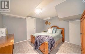Oshawa (Mclaughlin) apartment for rent - A bedroom with a bed, nightstand, and a wooden cabinet.