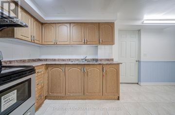 Markham (Milliken Mills West) apartment for rent - A kitchen with wooden cabinets and a black microwave.