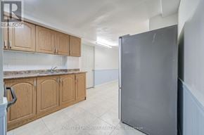 Markham (Milliken Mills West) apartment for rent - A kitchen with wooden cabinets and a refrigerator.