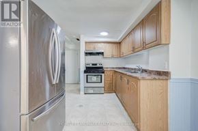 Markham (Milliken Mills West) apartment for rent - A kitchen with a stainless steel refrigerator and wooden cabinets.