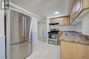 Markham (Milliken Mills West) apartment for rent - A kitchen with a stainless steel refrigerator and wooden cabinets.