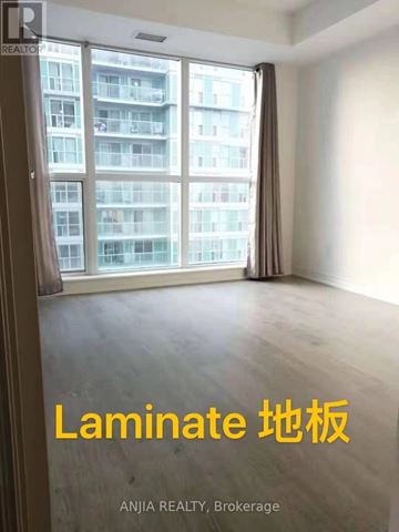 Toronto (Bendale) condo for rent - A room with a large window overlooking a building with the words "Laminate" written on the wall.