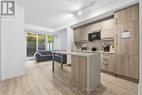 Markham (Unionville) condo for rent - A well-lit kitchen with wooden cabinets and a microwave above the stove.