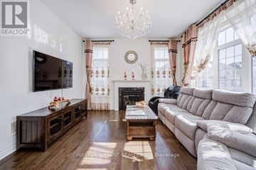 Bradford West Gwillimbury (Bradford) apartment for rent - A living room with a grey couch, a wooden coffee table, and a television mounted on the wall.