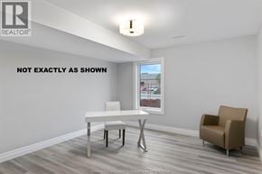 Lakeshore townhouse for rent - A white table with a white chair and a brown chair in a room with a window.