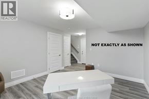 Lakeshore townhouse for rent - A white table is in the middle of a room with a staircase in the background.