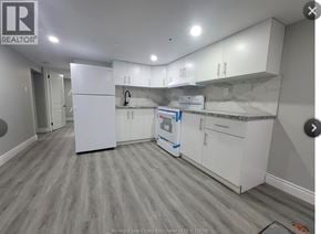 Windsor apartment for rent - A kitchen with white cabinets and a grey floor.