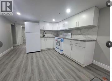Windsor apartment for rent - A kitchen with white cabinets and a grey floor.
