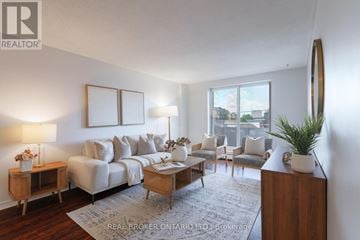 Hamilton (Raleigh) condo for rent - A living room with a white sofa, a wooden coffee table, and a large mirror on the wall.