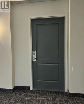 Whitchurch-Stouffville (Stouffville) condo for rent - A grey door with a handle and a keypad on the wall.