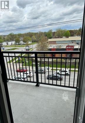 Whitchurch-Stouffville (Stouffville) condo for rent - A black metal railing with a view of a parking lot and buildings in the background.