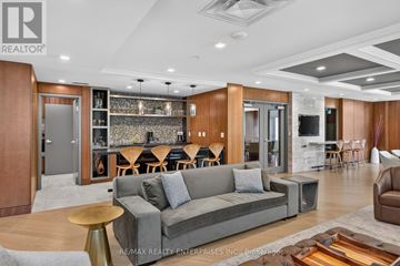 Mississauga (Clarkson) condo for rent - A modern living room with a grey sofa and wooden accents.