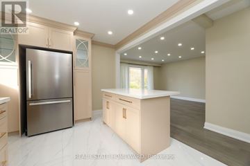 Toronto (Kennedy Park) apartment for rent - A modern kitchen with a stainless steel refrigerator and wooden cabinets.