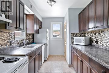 Windsor apartment for rent - A kitchen with dark wood cabinets and a white stove top oven.