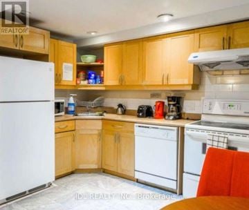 Toronto (Moss Park) townhouse for rent - A kitchen with wooden cabinets and white appliances.