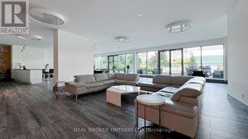 Toronto (Niagara) condo for rent - A spacious living room with a large sectional sofa and a coffee table.