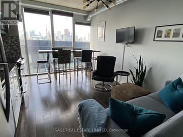 Toronto (Moss Park) condo for rent - A living room with a grey couch and a television on the wall.