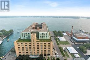 Toronto (Waterfront Communities) condo for rent - A large building with a green roof is situated by a body of water.