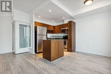 Toronto (Waterfront Communities) condo for rent - A modern kitchen with wooden cabinets and a central island.