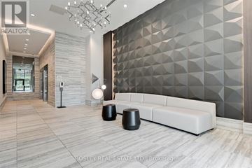 Toronto (Greenwood-Coxwell) condo for rent - A modern living room with a white sofa and a geometric wall design.