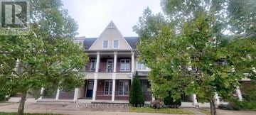 Pickering (Duffin Heights) townhouse for rent - A large house with a porch and a tree in front.