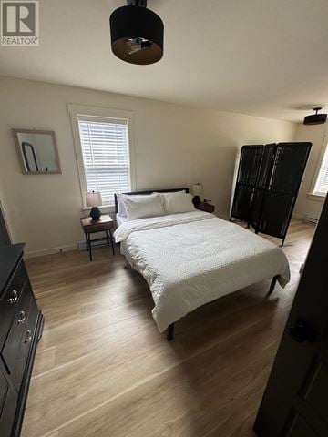 St. John's apartment for rent - A bedroom with a large bed and a wooden floor.