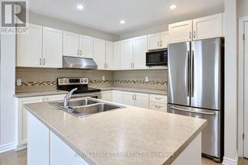 Ottawa townhouse for rent - A kitchen with white cabinets and a stainless steel refrigerator.