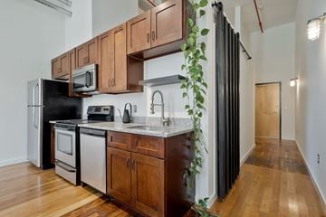 Nashville apartment for rent - A kitchen with wooden cabinets and a black refrigerator.