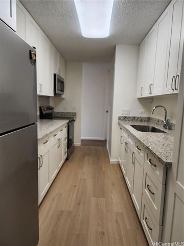 Honolulu apartment for rent - A kitchen with white cabinets and a granite counter top.