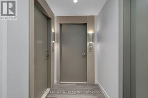 Brampton (Bram East) condo for rent - A hallway with a door and a wall-mounted light fixture.