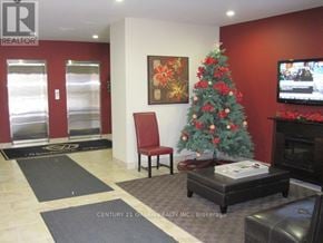 Guelph (Downtown) condo for rent - A living room with a Christmas tree and a flat screen TV.