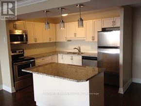 Guelph (Downtown) condo for rent - A kitchen with a granite countertop and stainless steel appliances.