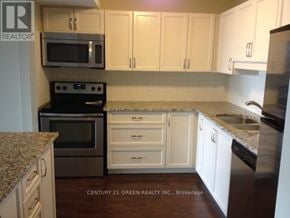 Guelph (Downtown) condo for rent - A kitchen with white cabinets and a granite countertop.