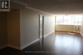 Guelph (Downtown) condo for rent - A room with a doorway leading to another room and a window with a view of a city.