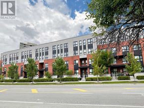 Toronto (L'amoreaux) townhouse for rent - A multi-story building with a red brick facade and a parking lot in front.
