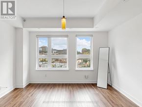 Toronto (L'amoreaux) townhouse for rent - A realtor brochure is displayed on the wall of a spacious room with a large window and wooden flooring.