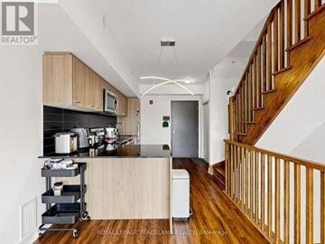 Toronto (L'amoreaux) townhouse for rent - A kitchen with a stove top oven and a counter top with a microwave.