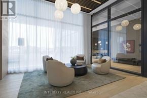Brampton (Bram East) condo for rent - A modern living room with white furniture and a glass door leading to a balcony.
