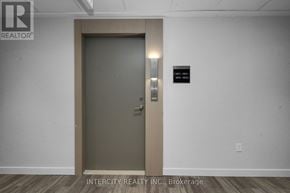 Brampton (Bram East) condo for rent - A brown door with a handle and a sign on the wall.