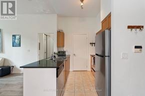 Toronto (Niagara) condo for rent - A kitchen with white cabinets and a black countertop.