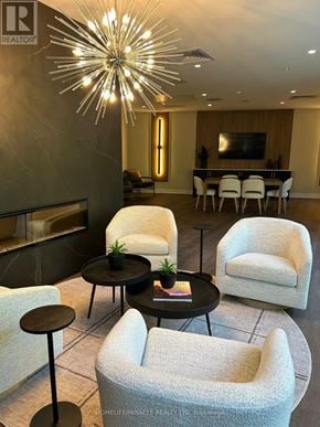 Kitchener house for rent - A living room with a large chandelier and a dining table with chairs.